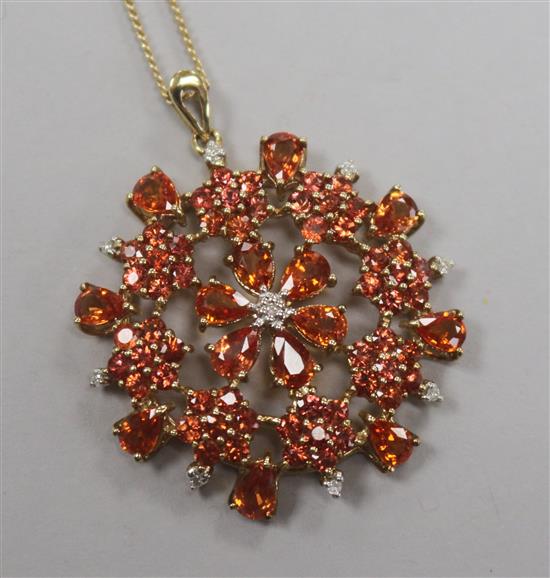 A 9ct gold, orange sapphire? and diamond set pendant, on a 9ct gold fine link chain, pendant 39mm.